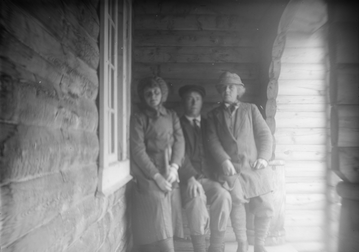 Sjodalen, En mann og to kvinner sitter under tak ved inngang til Bessheim