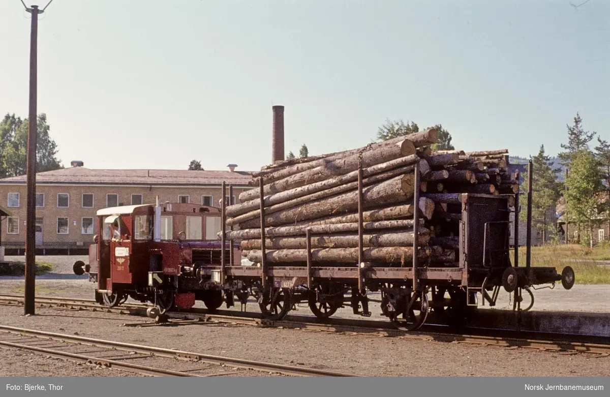 Skiftetraktor Skd 206 13 med godsvogn litra T3 nr. 6827 med tømmerlast på Dokka stasjon