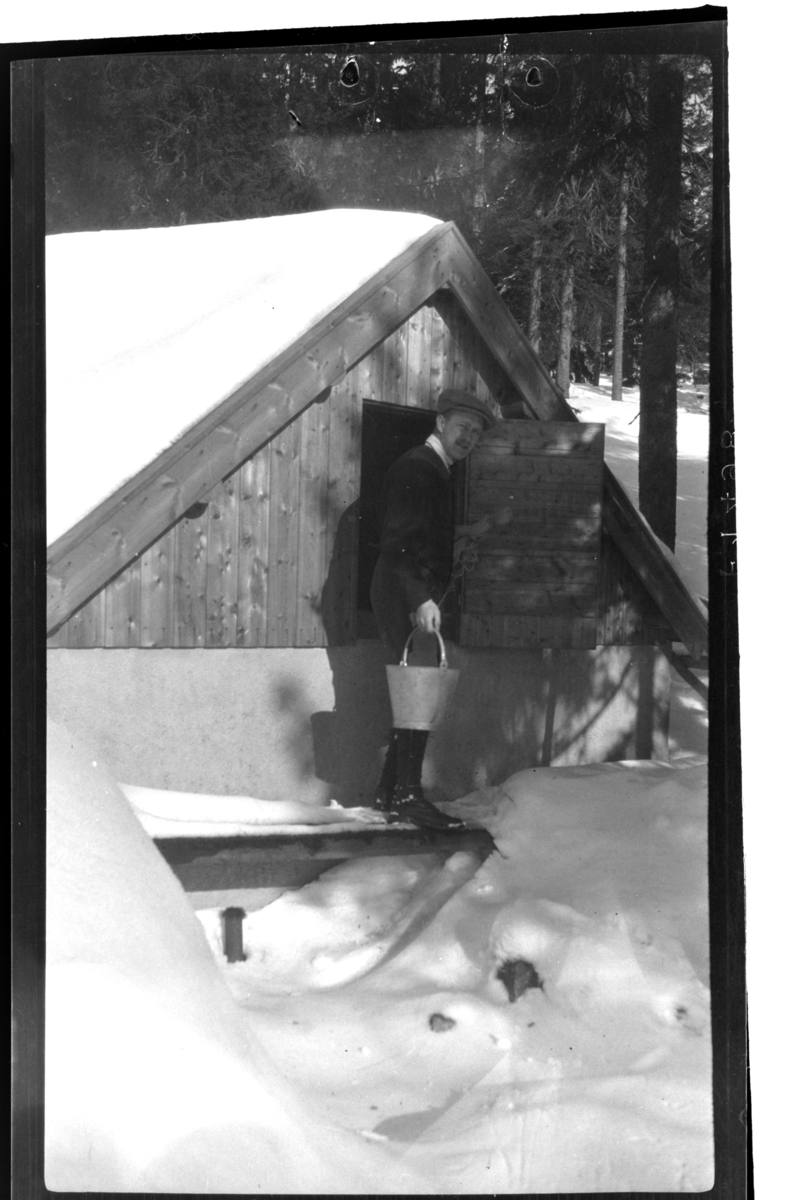 Rolf Sundt sr. henter vann i brønnen på Villa Knyggen. Fotografert 1918-1919.