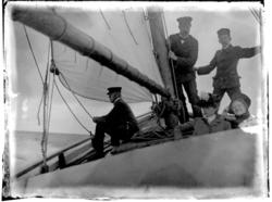 To kvinner og tre menn i seilbåt. Antagelig fotografert 1903