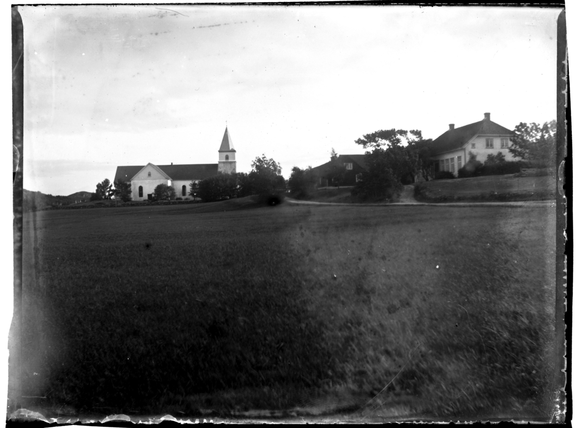 Vanse kirke, Farsund. Ukjente bygninger ligger ved siden av. Fotografert ca. 1903.
