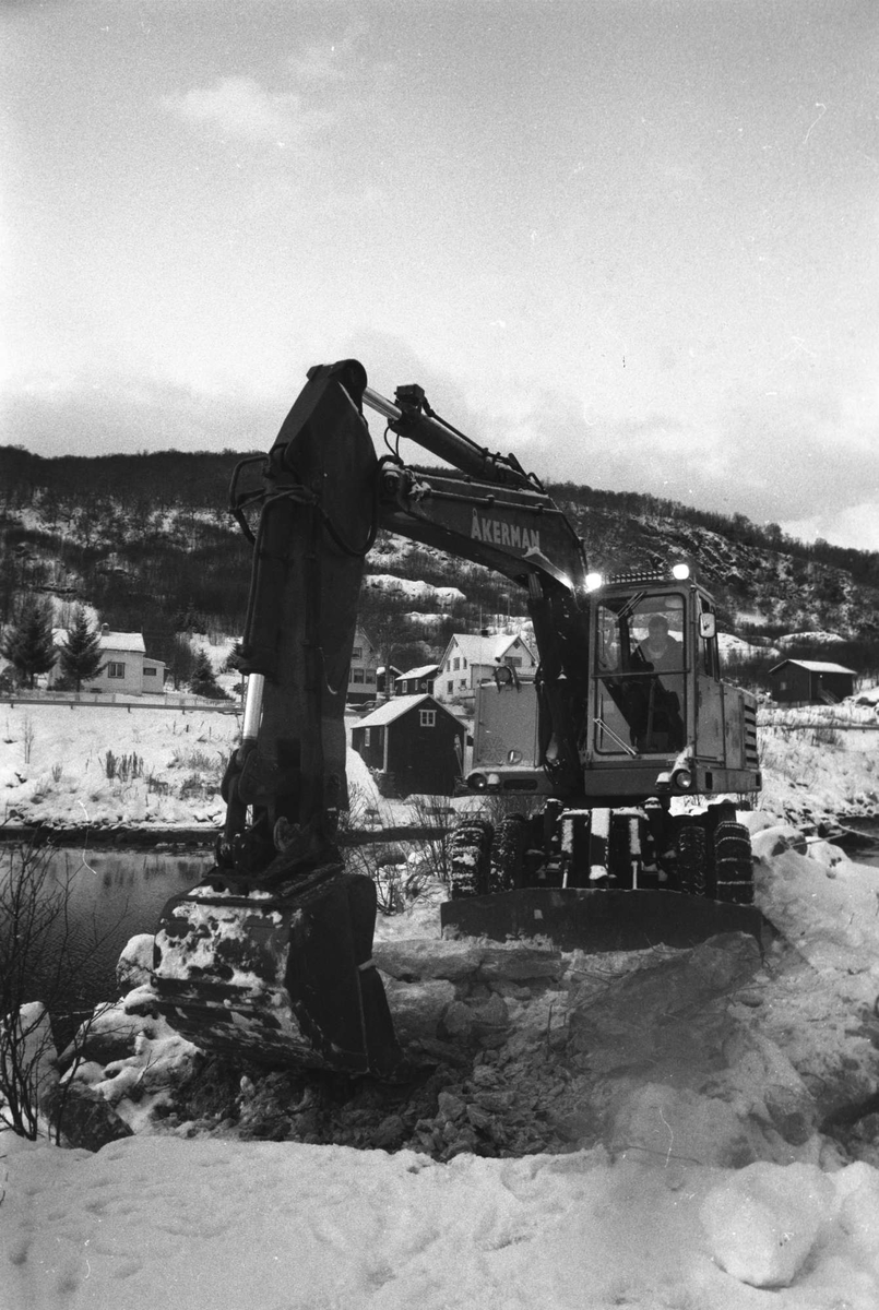 Gravemaskin arbeider på molo på Bjarkøy.