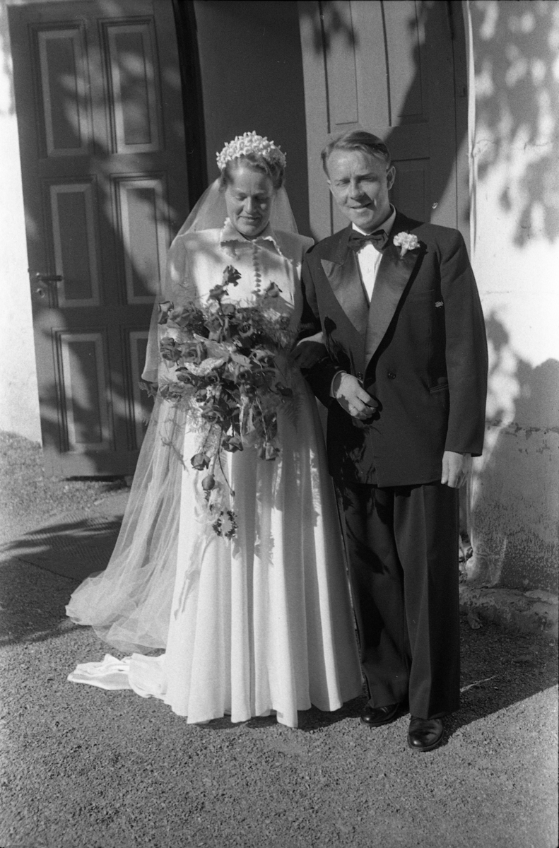 Brudeparet Else Rustad og Edvard Narum fotografert foran inngangen til Hoff kirke. Serie på 11 portretter, noen i helfigur, andre i halvfigur.
