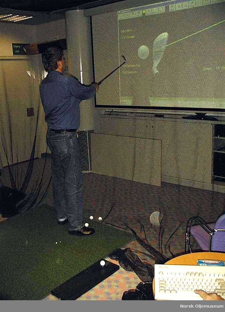 En person spiller golf i golfsimulatoren på Draugen.