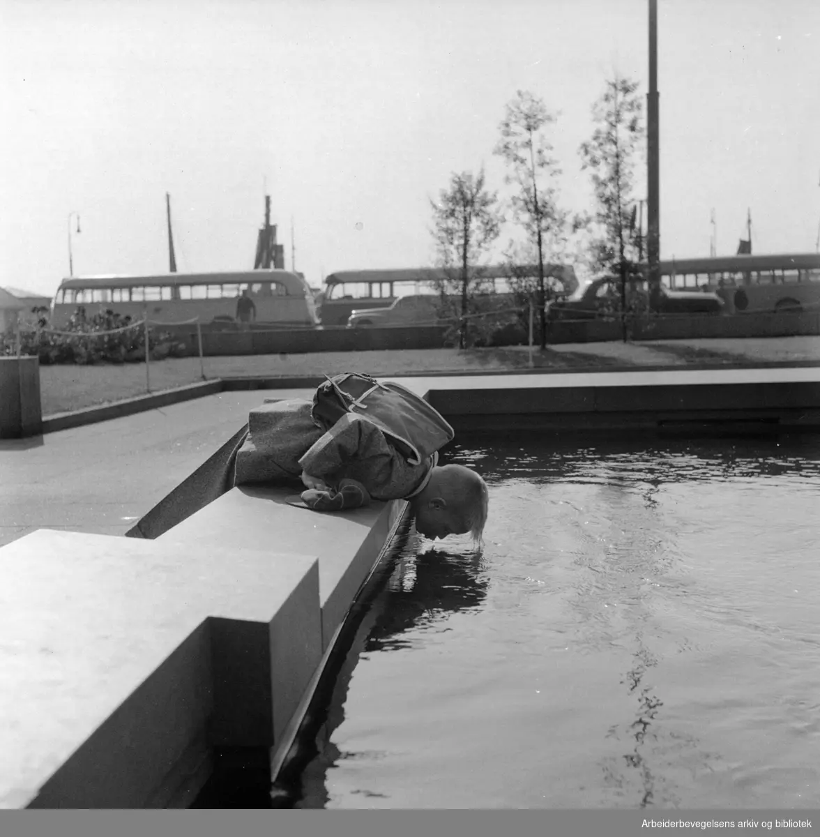 Rådhusplassen. Bjørn Harald Østby speiler seg i vannflaten. September 1956