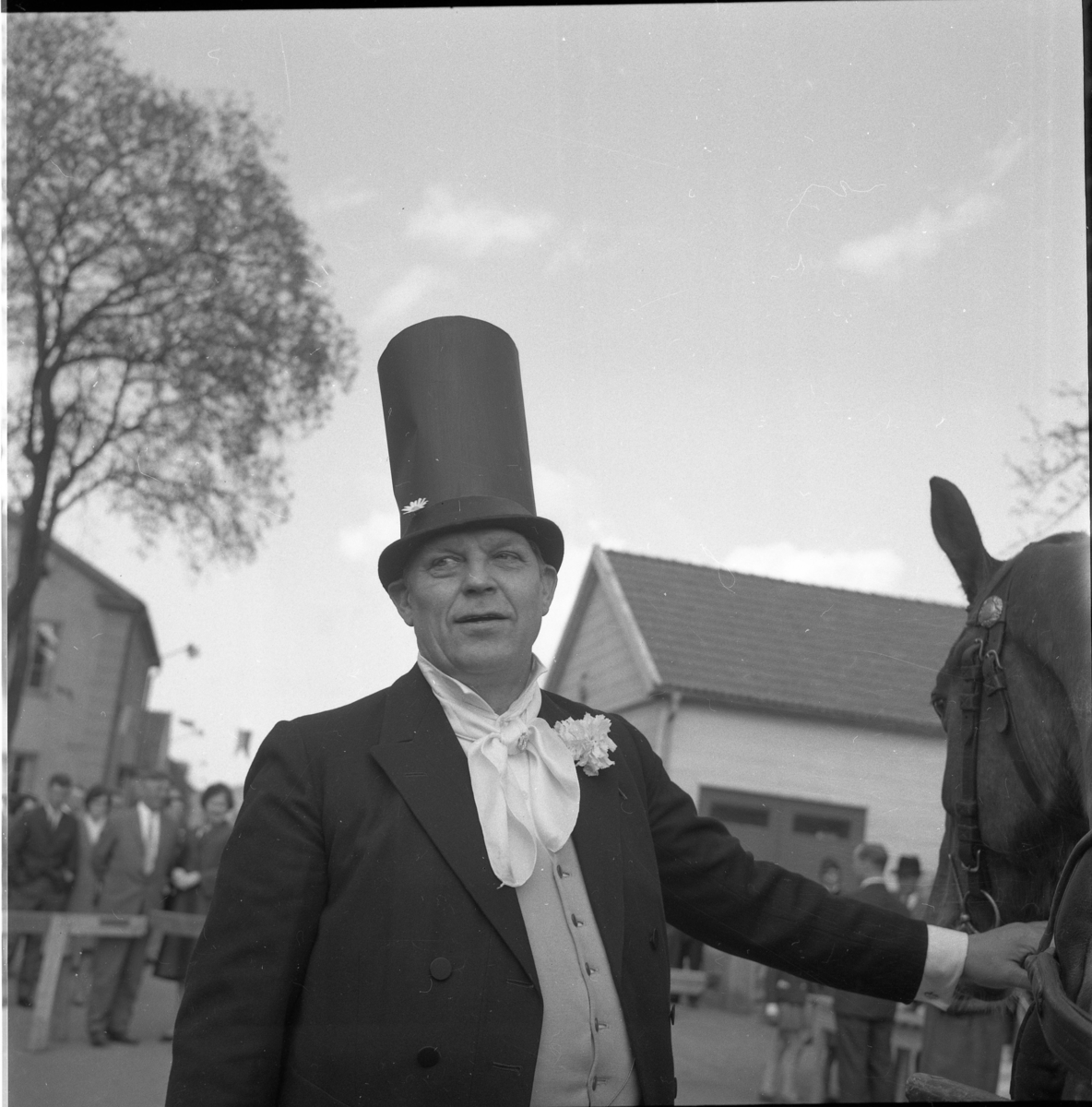 Lions vårmarknad 1964. En högtidsklädd Lauritz Madsen med extra hög hatt står och håller en häst.