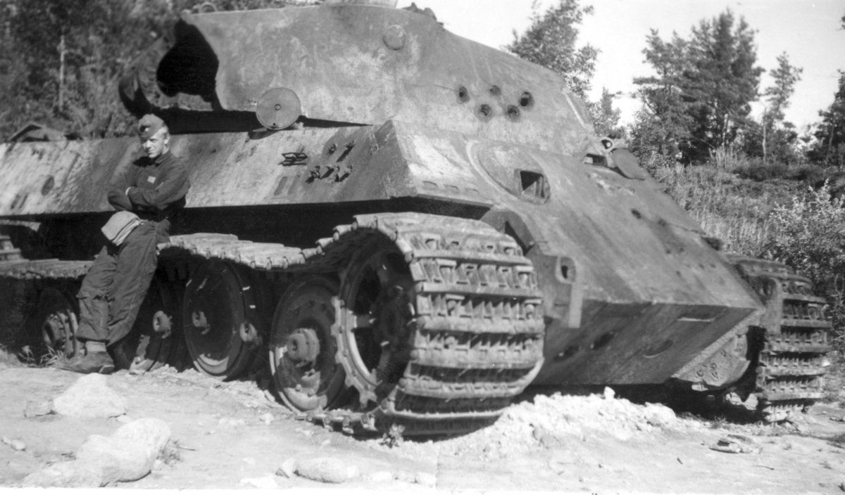 Tysk stridsvagn Kungstiger som beskjutits och analyserats på Karlsborgs provskjutningsfält 1950.
Tornet uppskuret och bandet minsprängt.
Vid vagnen står Fu Einarsson P 2.