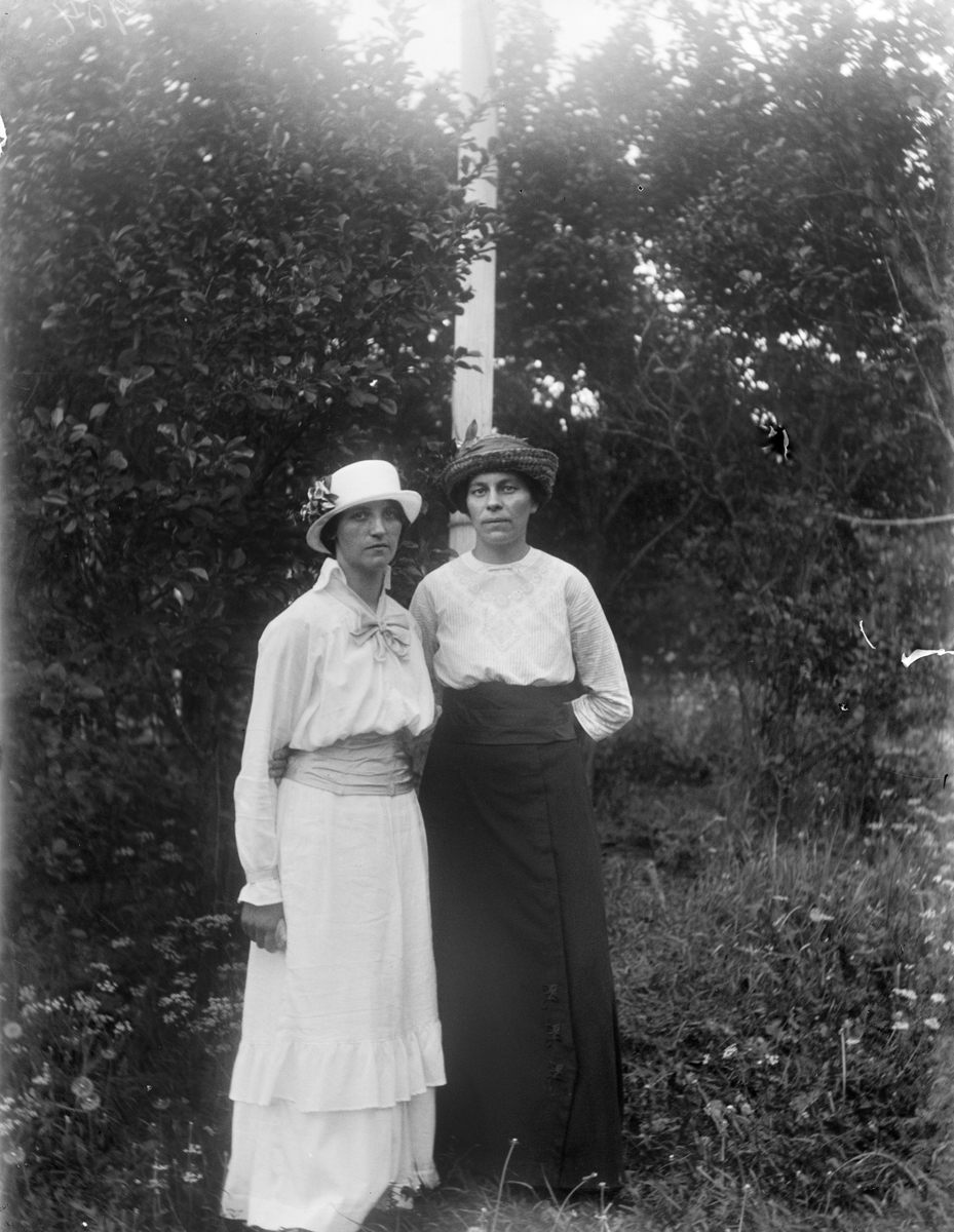 Hildegard Pettersson med sällskap vid flaggstång i trädgården, Sävasta, Altuna socken, Uppland