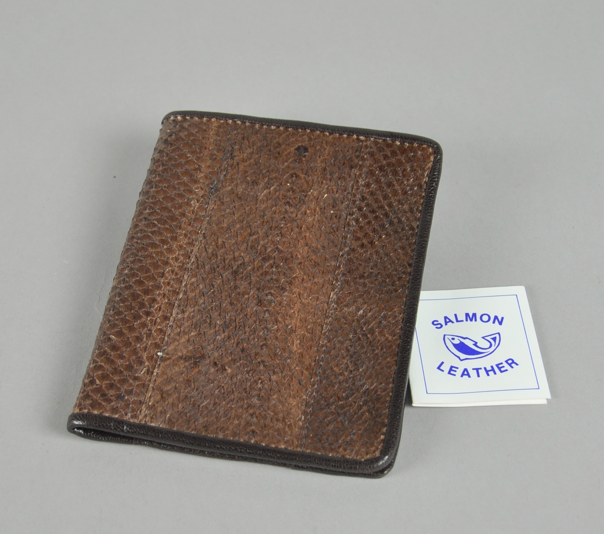 Lommebok av lakseskinn med plass til sedler, kort og mynter i lomme med glidelås.