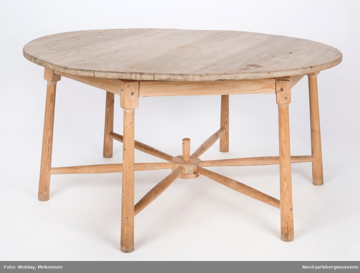 Rundt, umalt bord med seks tynne ben, som er festet med spiler mellom bena, inspirert av kjerrehjul. Bordplaten er delt i to (sekundært?)