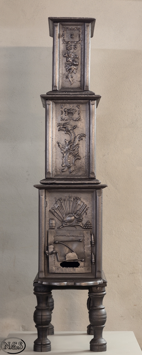 Ovn i 3 etasjer med hovedmotivet, Venus krever våpen til Æneas, på begge langsider 1. etasje.  Øverst på kortsidene 1. etasje krigerske emblemer. 2. og 3. etasje rokokko-ornamentik med uregelmessig åpning. Kortsidene med blad og blomster i sløyfe.