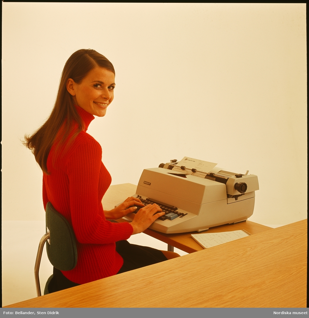 Ung kvinna vid skrivmaskin.