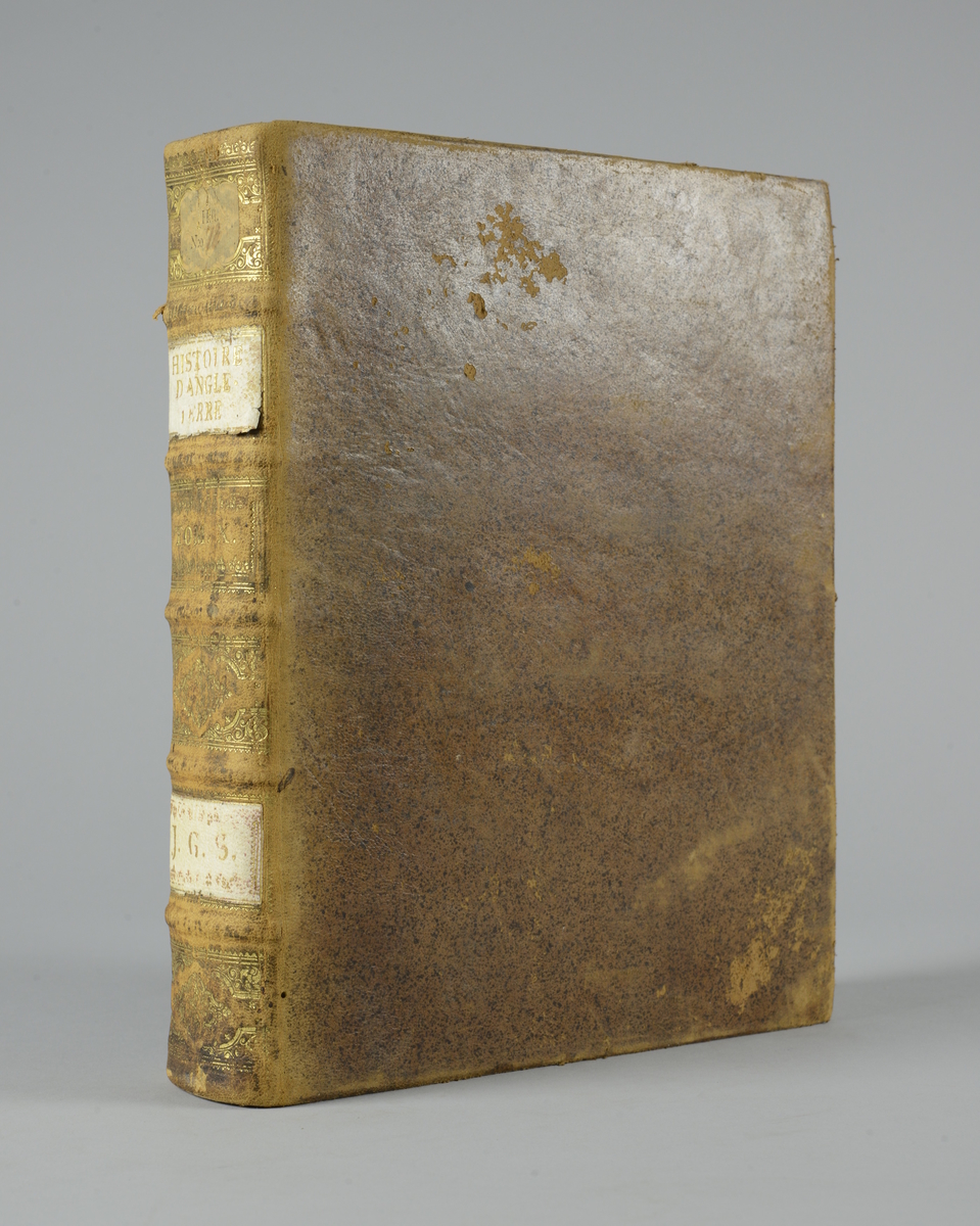 Bok, "Histoire d´Angleterre" av Paul Rapin de Thoyras, utgiven 1727, del 10. 
Skinnband med fem upphöjda bind med guldpräglad dekor, blindpressad och guldornerad rygg, fälten skadade. Påklistrad pappersetikett. Pärmarnas insidor marmorerade. Stänkt snitt.