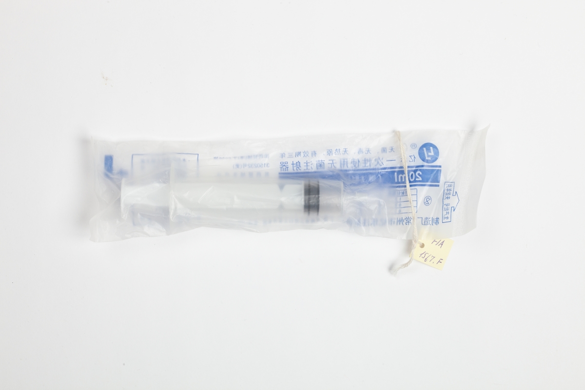 En engangssprøyte som er forseglet i en gjennomsiktig plastpakning med påtrykte blå kinesiske tegn