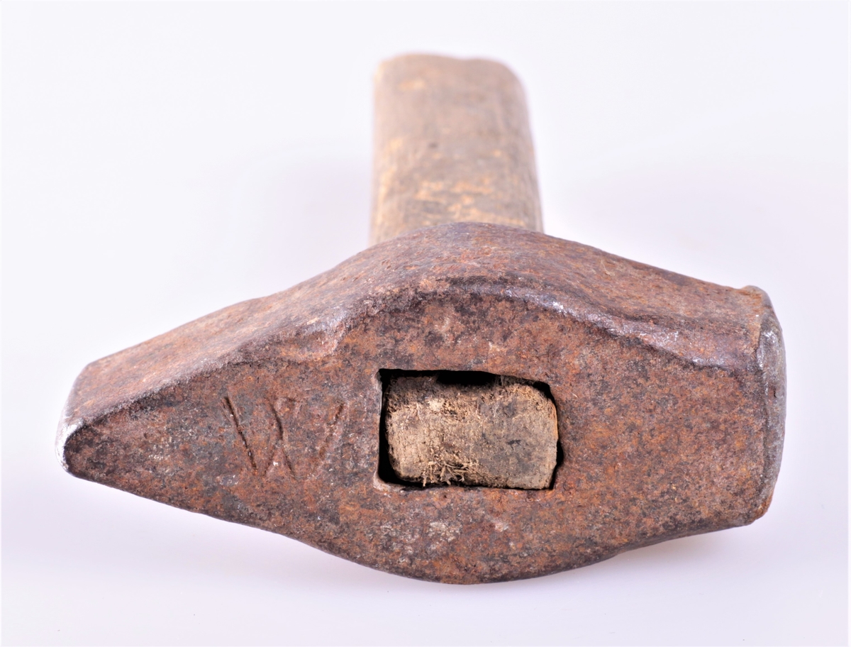 Hammeren har et kort håndtak av tre, et tungt og massivt hode av jern. Hammeren er antagelig hjemmesmidd. 
Initialer på hammeren W