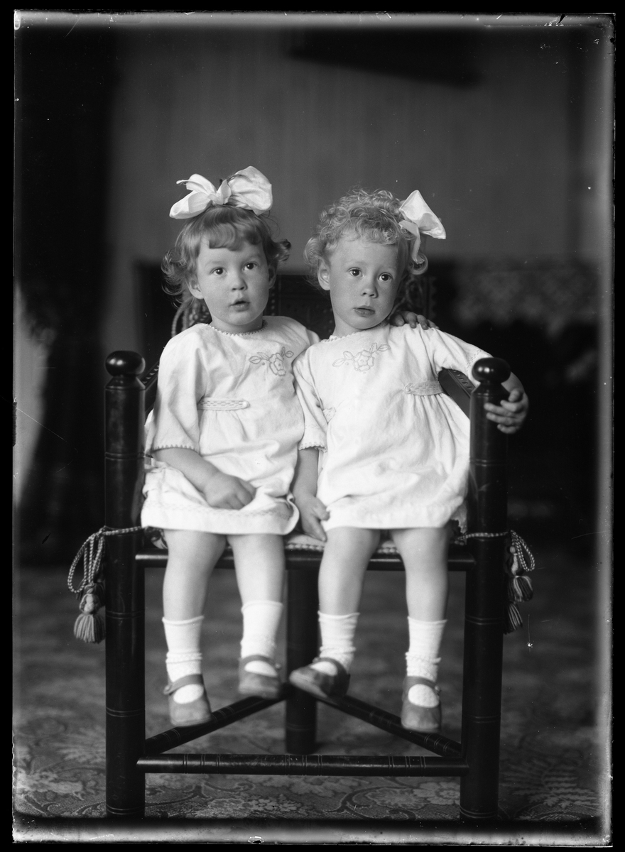 Syskonen Ester och Birgit Tollstadius, klädda i vitt med rosett i håret.