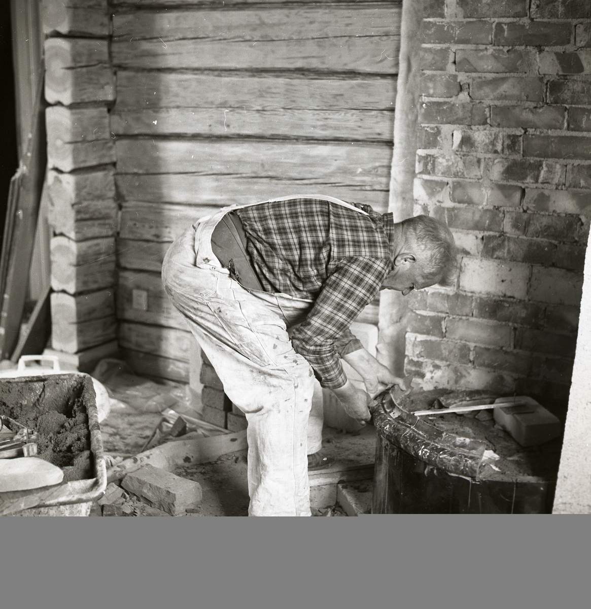 En man bygger ihop en kakelugn, 1968.