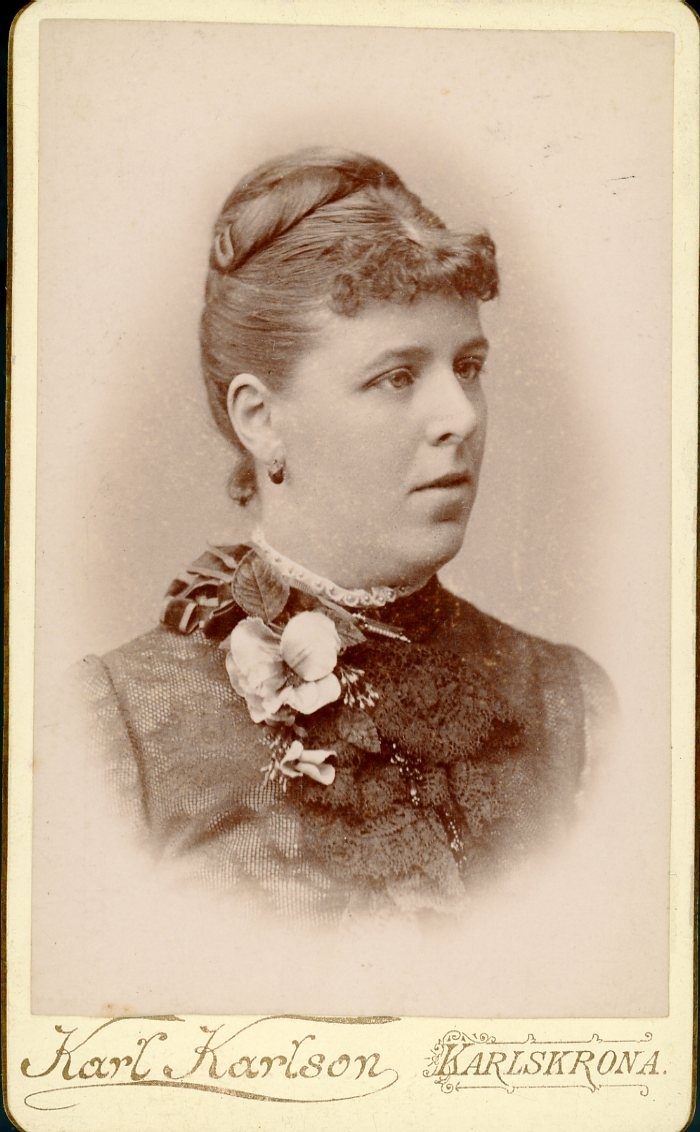 Kabinettsfotografi: "Aug. Claussen", bröstbild med blomsterbrosch vid halsen.
Eller möjligen Claessen.