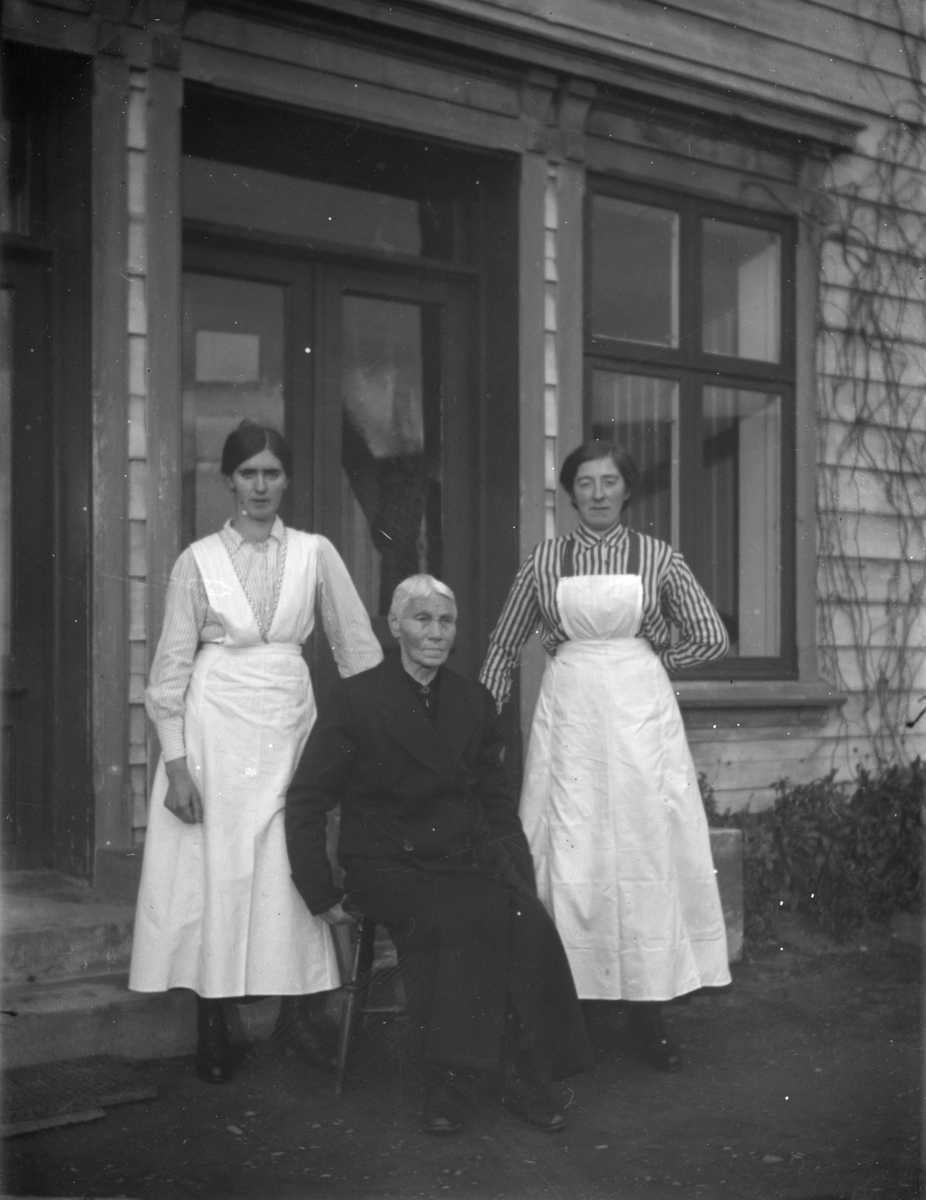 Gruppebilde av en eldre og to yngre kvinner, antagelig Anne Evenvold i midten