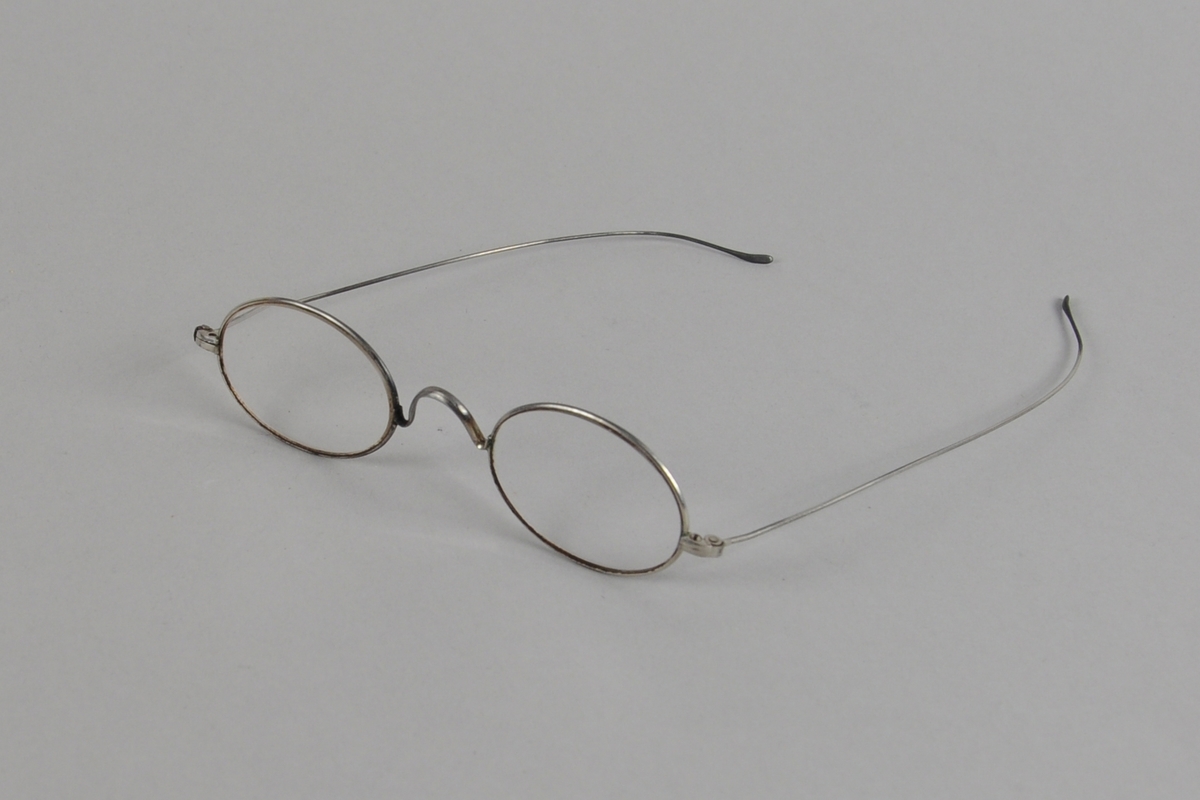 Ovale briller med metallinnfatning.
