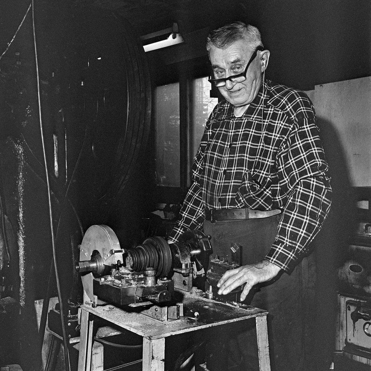 Verktøymaker og slukfabrikant Jens Hansen fra Gjøvik, fotografert i verkstedet i 1970.  Hansen var særlig kjent for Devon-slukene sine, metallagn som var formet som små fiskeetterlikninger med «propellvinger» som fikk dem til å rotere hurtig i vannet med kroker på kroppen og i haleenden.  Hansen konstruerte sjøl maskiner for produksjon av denne sluktypen i 1930-åra.  Ideen skal han ha «lånt» fra en maskin som kvesset rivetinner på Christiania Spikerverk.  I 2006 publiserte Erland Fjell følgende beskrivelse av produksjonsprosessen i tidsskriftet «Alt om Fiske»: «Lange messingrør kappes, før de glødes på 600 grader i en time.  Etter litt avkjøling og en omgang tromling i finhakket flis av furu for å fjerne glødeskall, legges rørbitene mellom to former og føres manuelt inn i en lukket maskin som roterer innvendig og hamrer til den ytre formen.  På de største slukene må det til enda et par omganger med gløding før denne delen av prosessen er ferdig.  Deretter skal det skjæres spor til kroksettet, og det skal stukes riller til ørene, som loddes fast med en tråd av 40 % sølv – til tre tusen blanke kroner for en halv kilo.  Etter dette sendes slukene til påføring av kobber-, gull- eller sølvbelegg.  Så kommer stafferingen, altså pålegging av farger og mønstre, før den siste varmeherding på 250 grader.  Da gjenstår bare montering av kroksett.»  Jens Hansens maskiner er seinere overdratt til Sole arbeidstreningssenter på Skreia på Toten, som da Erland Fjell skrev sin artikkel videreførte produksjonen av noe de markedsførte som «TotenDEVON».  Etter den tid er virksomheten flyttet til Lena på Østre Toten, der virksomheten drives videre under navnet «Lena Produkter AS».