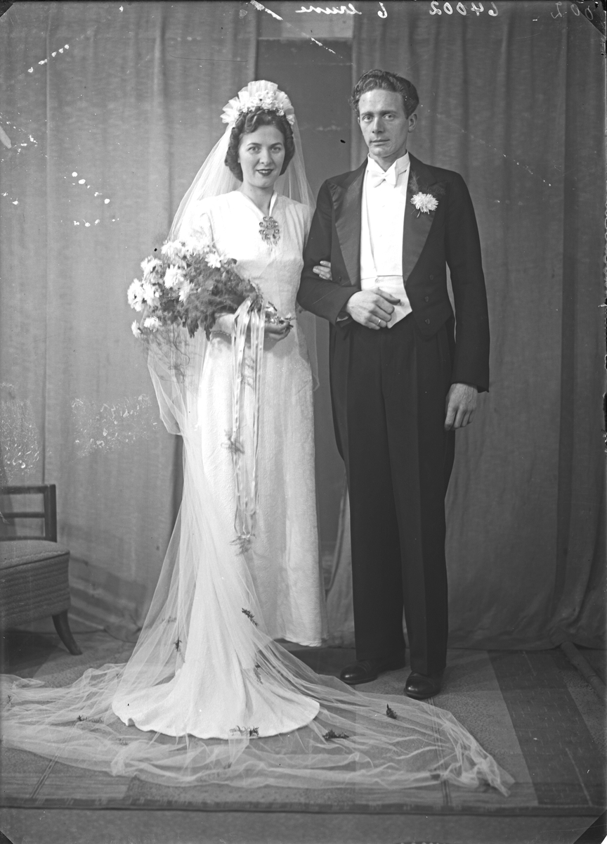 Portrett. Brudebilde. Ung kvinne i hvit brudekjole med slør og ung mann med mørk dress. Brudepar. Bestilt av Audun Kvale. Hordalandsgt.