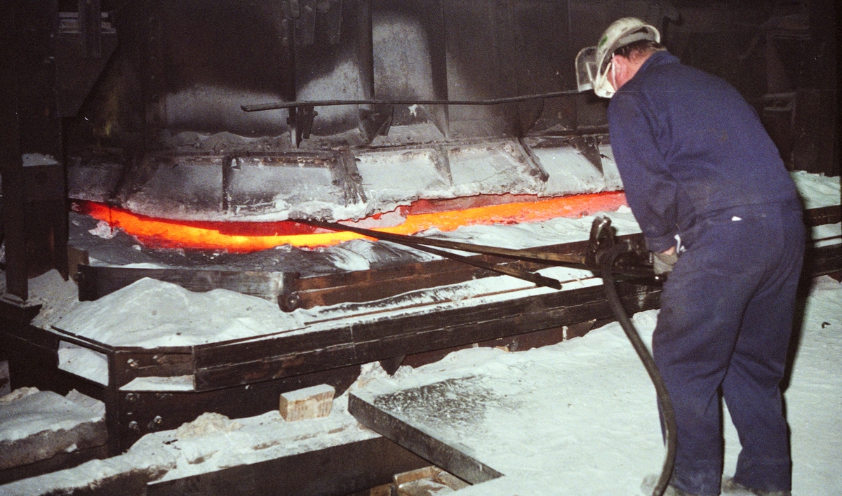 Industriarbeidar ved smelteomnen på DNN aluminium.