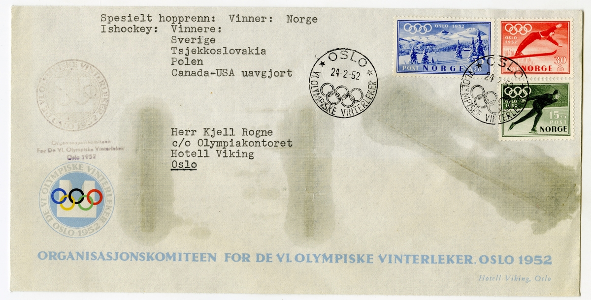 Konvolutt fra Organisasjonskomiteen for OL i Oslo 1952 og emblemet for lekene på venstre siden. Konvolutten har tre frimerker (et grønt med en skøyteløper, et rødt med en skihopper og et blått med fjell- og vintermotiv) og er stemplet den 24. februar 1952. De olympiske ringer er en del av stempelet.