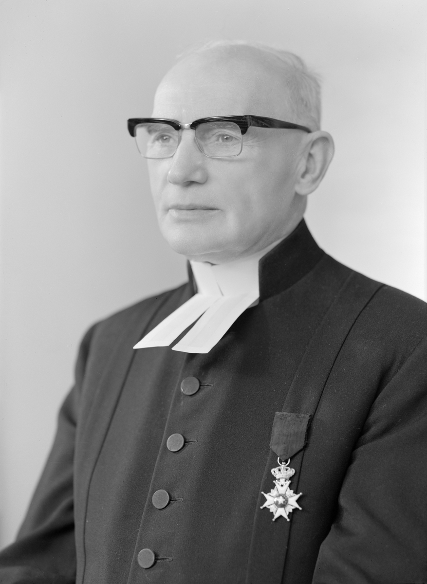 Porträtt av Gustaf Rydmalm. Vid tiden kyrkoherde i Ulrika församling. Tidigare hade han innehaft samma tjänst i Vikingstad. Från 1931 gift med Greta Elisabet, född Nilsson.