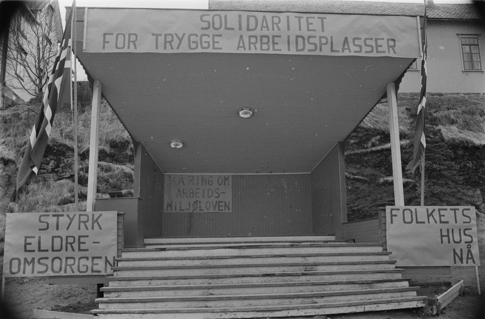 1.Mai-tog i Sandnessjøen. Paviljongen pyntet med bannere med slagord ...