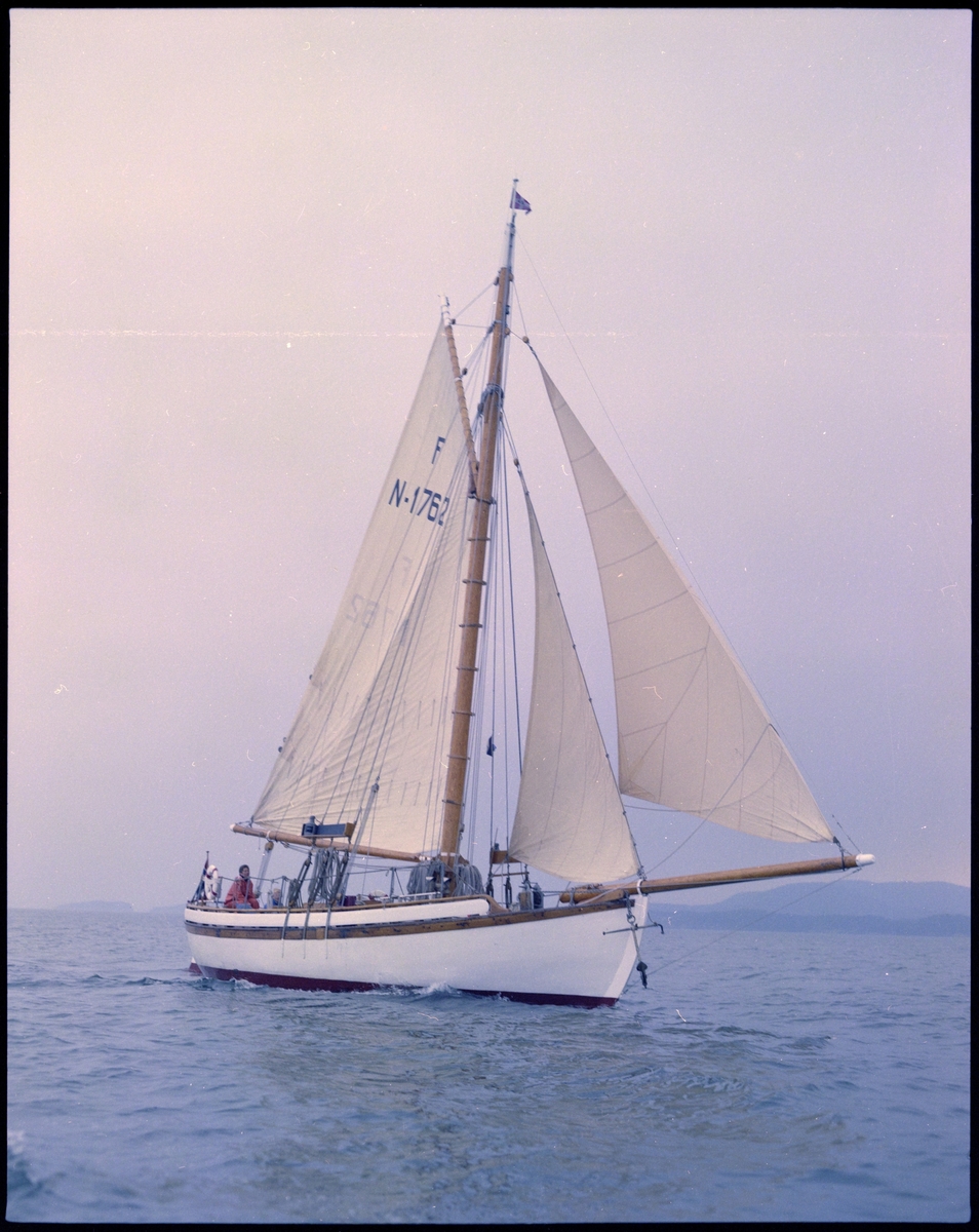 Seilskøyta "Heidrun" på sjøen. To personer sitter ombord.