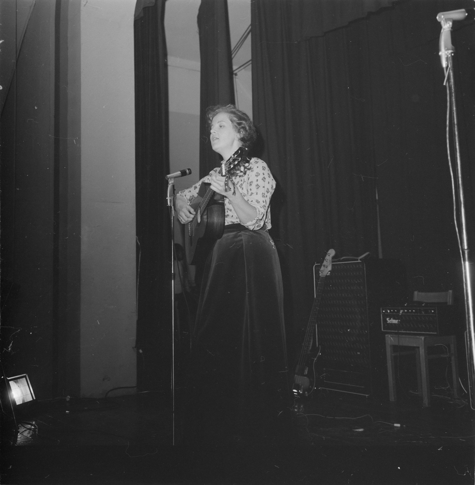 Tiendebyttet 1966. Kvinne som underholder med gitar i kinoen.