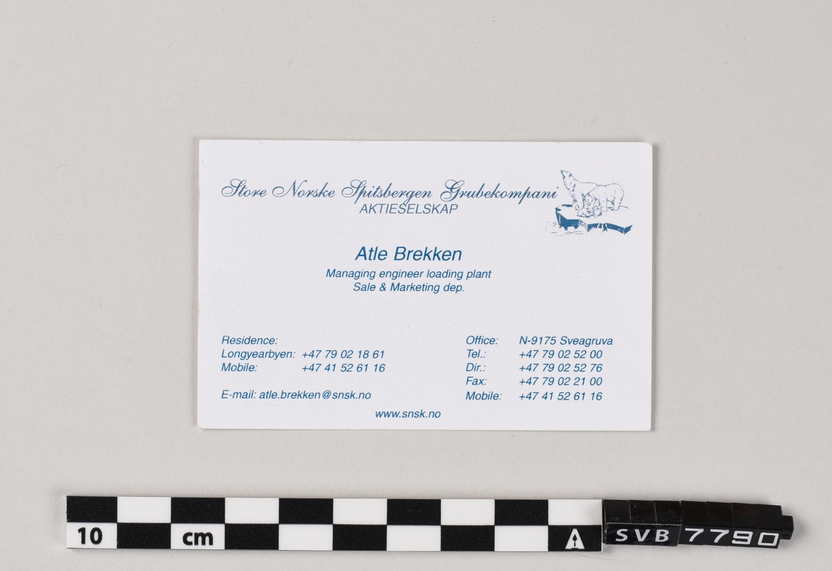 Firkantet stykke papp med trykt tekst og Store Norske Spitsbergen Grubekompani Aktieselskaps sitt logo. Det er trykk på begge sider. På den ene siden er det på engelsk og på den andre siden er det på norsk.