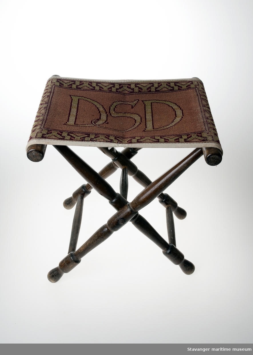 En taburett i tre og tekstil, med DSD logo på setet.
