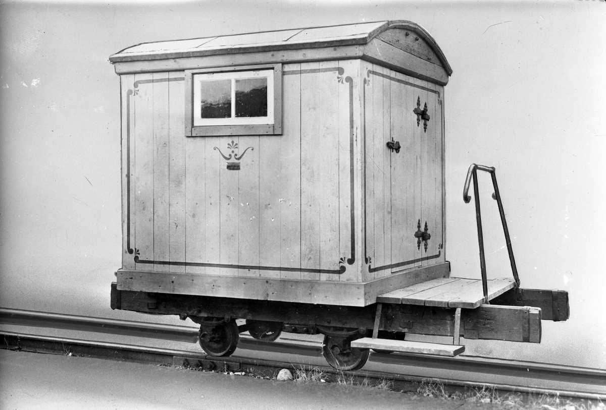 Täckt smalspårig personvagn från Kroppa järnväg med liten plattform med räcke i ena änden. Rekonstruktion av vagn från 1854. Vissa delar är original. Spårvidd ca 690 mm.
