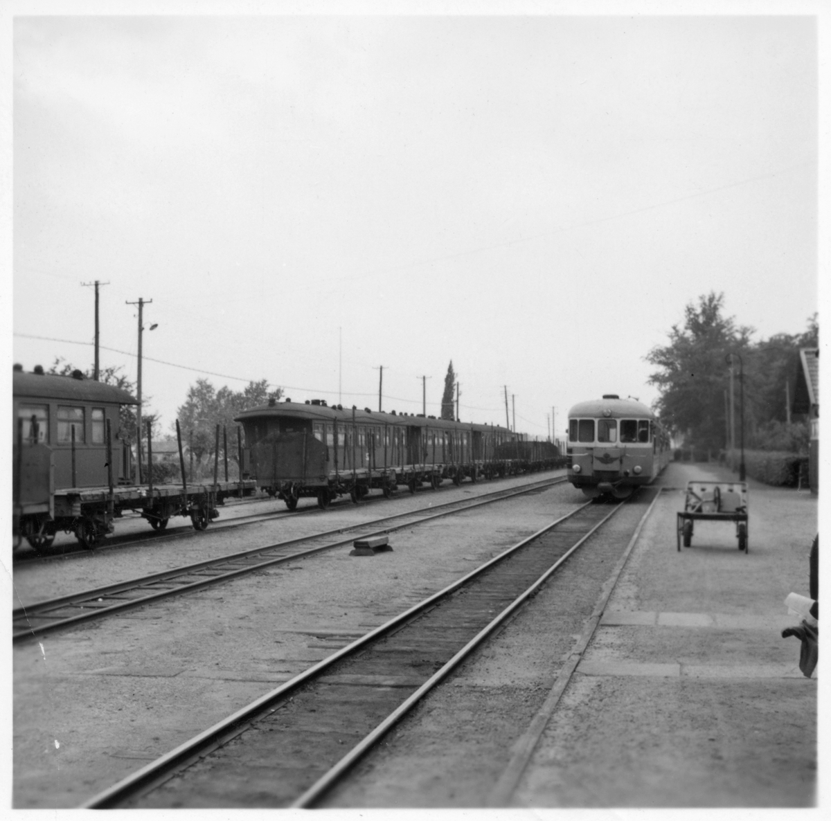 Del av bangården vid Axvall station. Stationen öppnades 1874 med en- och en halv vånings stationshus i trä. Den upphörde 1961.
Motorvagnen är troligen SJ Yo1 474, tillverkad av  Hilding Carlsson , slopad 1961.