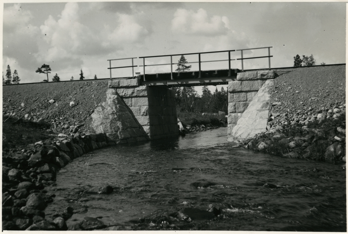 Järnvägsbro över Hundträskbäcken.
Järnvägen som går genom Jokkmokks område sträcker sig över många vattendrag, bäckar, åar och älvar. Broarna som byggdes över de anpassades till terrängen. De var framförallt funktionella men, deras utseende gick från väldigt enkla, grovhuggna till sublima, estetiskt utformade valvbroar.