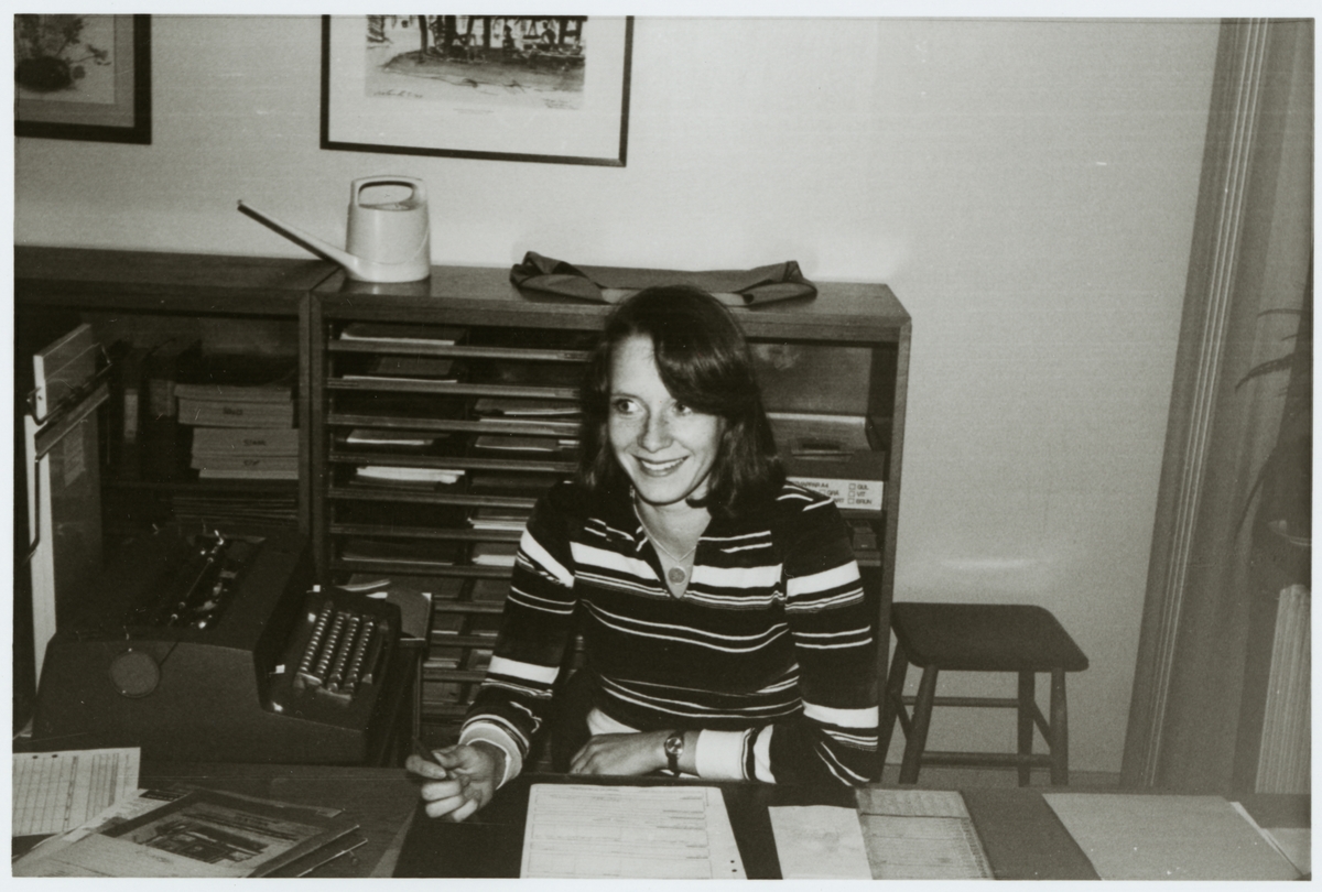 Kvinna bakom ett skrivbord på ett kontor.