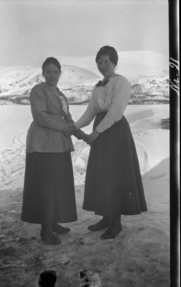 Portrett av to kvinner stående utendørs.