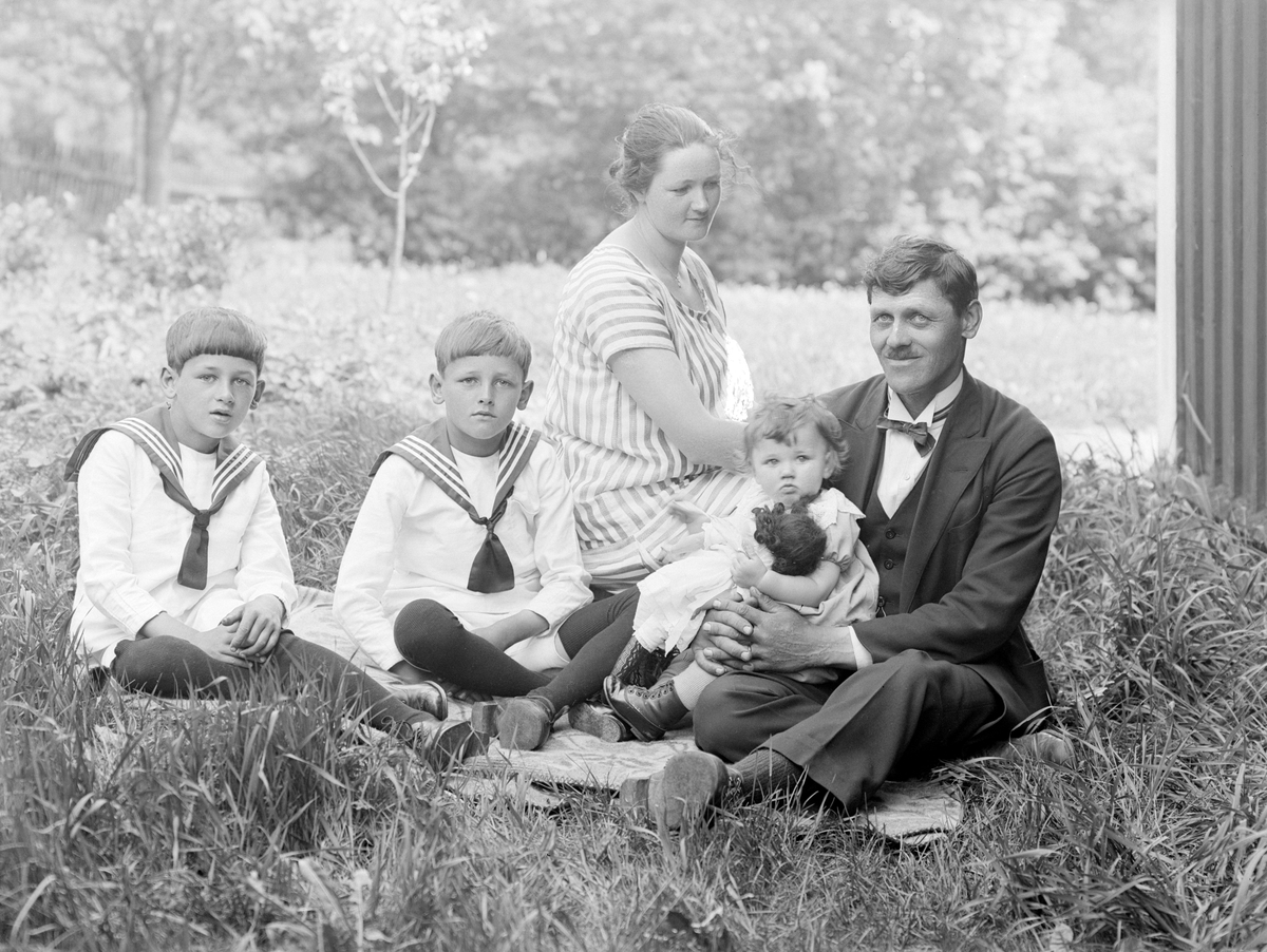 Makarna Gotthard och Jenny Johnsson har tillsammans med barnen slagit sig ned i gröngräset invid hemmet Forserum i Svinhult socken. Paret disponerar hemmet i egenskap av makens yrke som kronojägare. Bild från sommaren 1926.