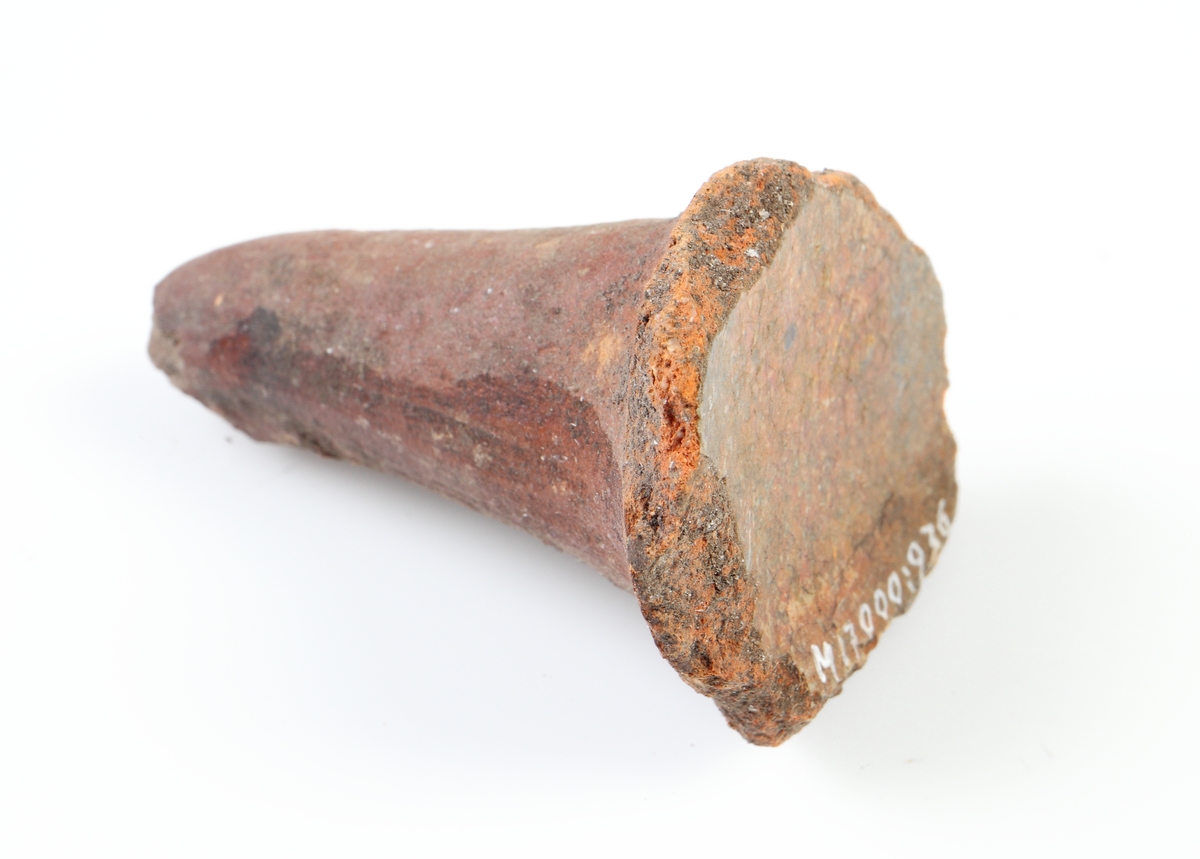 Koniskt ben, sannolikt från en trebensgryta i yngre rödgods. Rödbrun glasyr på kärlbukens insida. Tillverkad i södra Skandinavien.