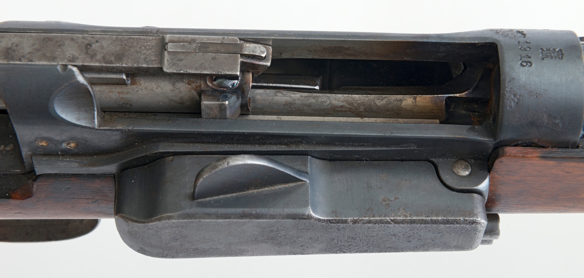 Riflegevær av Krag-Jørgensen-type, antakelig produsert ved Kongsberg våpenfabrikk i 1916.  Våpenet er 101 centimeter langt, hvorav stokken er 78, 8 centimeter.  Største bredde (11, 8 centimeter) er målt ved enden av kolba, der det later til å ha sittet et kappebeslag, som ikke er intakt.  Beslaget er borte, men utsparinger og skruehull tyder på at geværkolba har hatt en slik forsterkning i enden.  Kolba har ovalt tverrsnitt og glattpusset overflate.  Ved kolbehalsen er det en markert forsenkning på oversida og en markert knopp på undersida.  Foran er det rombeformete, skraverte felt på begge sider av stokken.  På den fremre delen av stokken er det hulkilformete forsenkninger i lengderetninger, som sannsynligvis skulle gi brukeren et godt venstrehandsgrep om våpenet.  Geværet har hatt bærereim, som har vært festet i ei bøyle på undersida av kolben og i beslaget som forbinder den fremre delen av stokken og løpet.  Et hull på undersida av og på tvers av kolben er spunset med treplugger.  Våpenet har en magasinbrønn for patroner på høyre side.  Bakerst på sluttstykket er det en knast, som når den vendes mot høyre, låser våpenet.  Med unntak av det nevnte beslaget rundt fremdre del av stokken og løpet, som er merket «129», er både stokken og stålkomponentene stemplet «951», noe som betyr at våpenet stort sett består av originaldeler.  Siktet er imidlertid ikke originalt (jfr. gjengitt brev fra giveren under fanen «Historikk»).  Her er det montert et stolpesikte foran og et dioptersikte bak.  Produksjonsåret 1916 er påstemplet i forkant av sluttstykket, under Kongsberg våpenfabrikks monogram. 