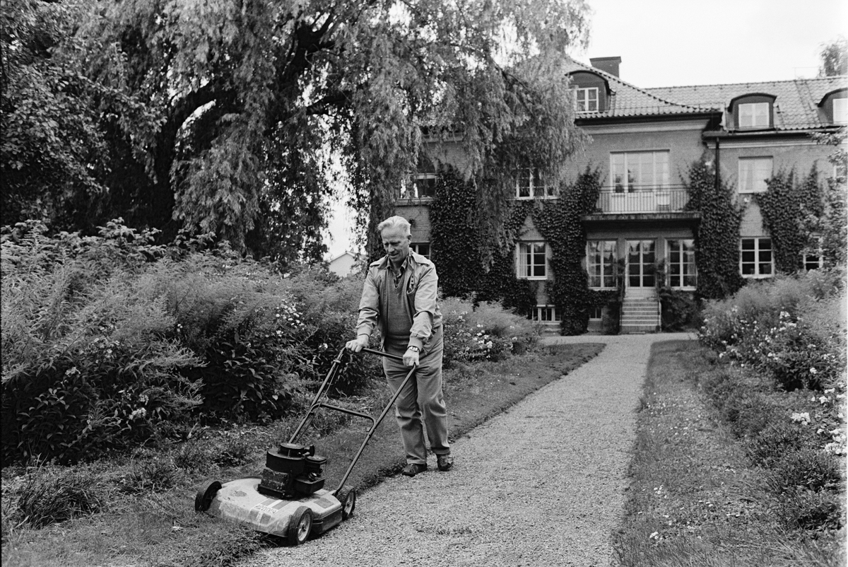 Vaktmästare Stig Eriksson klipper gräset i trädgården som hör till lättvårdsavdelningen Ringblomman och Gillbergska barnhemmet, Sysslomansgatan 37 - 39, Uppsala 1986