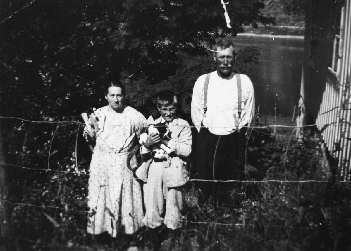 Eldre par m/gutt og katt i hage.Veimann i Torsken ca.1940.