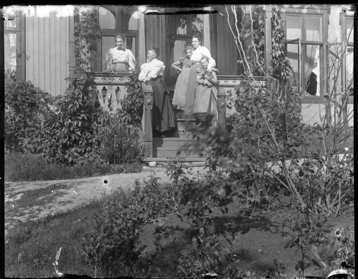 Foto av familie på trapp utenfor villa, 1890-tallet. Jenta til høyre holder på en katt

Antatt fotosamling etter Anders Johnsen.