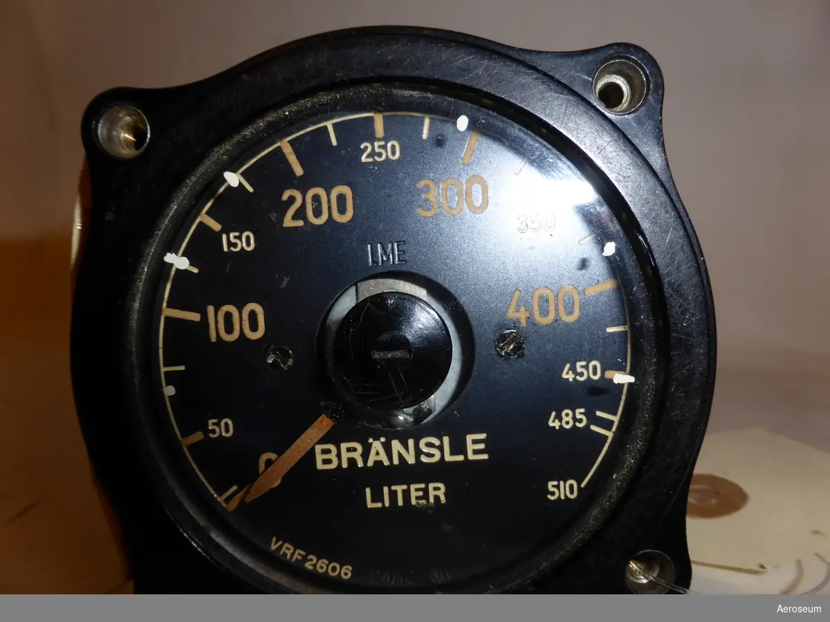 En Bränslemätare med svart bakgrund och runtom displayen och metallfärgad på sidorna och i botten.

I displayen står det: "LME", och "VRF 2606".

I botten står det: "10 VOLT".