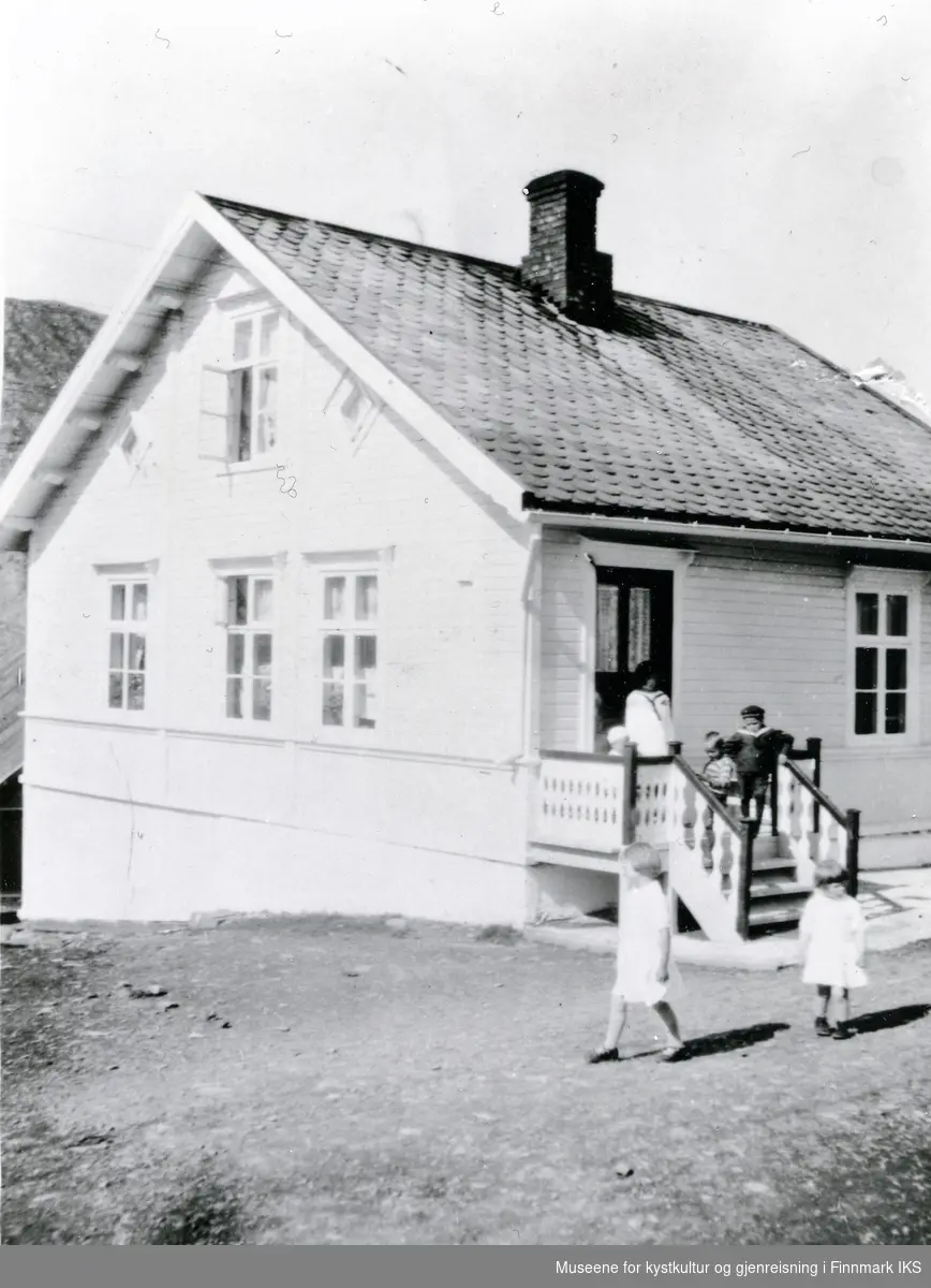 Nordvågen. Flere barn kledd i søndagsklær utenfor Johannes Klevstads bakeri- og bolighus. 1930-tallet.