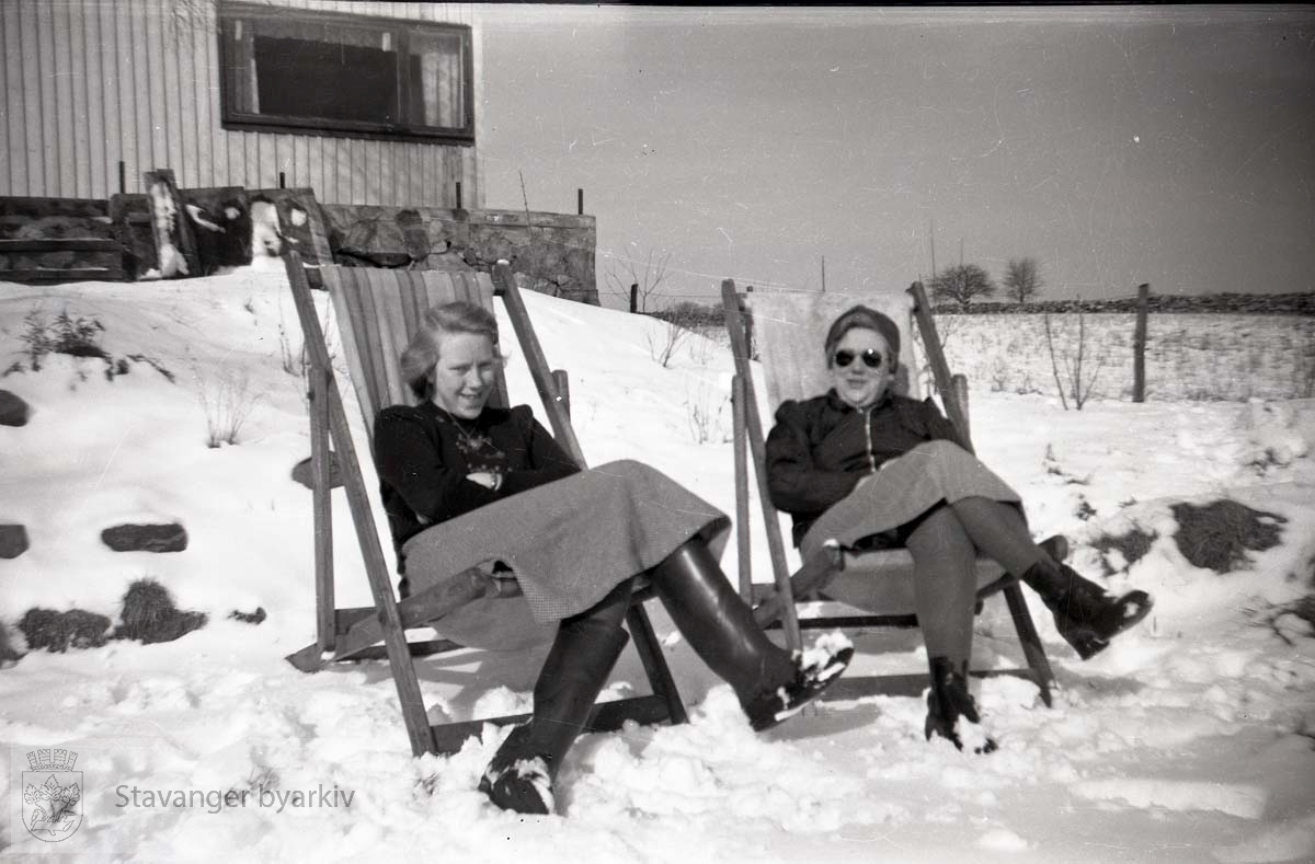 To kvinner i snøen foran hus..Bjørg Iversen til venstre.