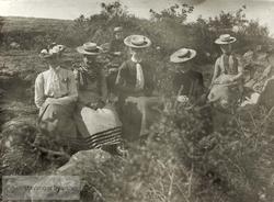 Fem kvinner med hatt og en gutt på tur