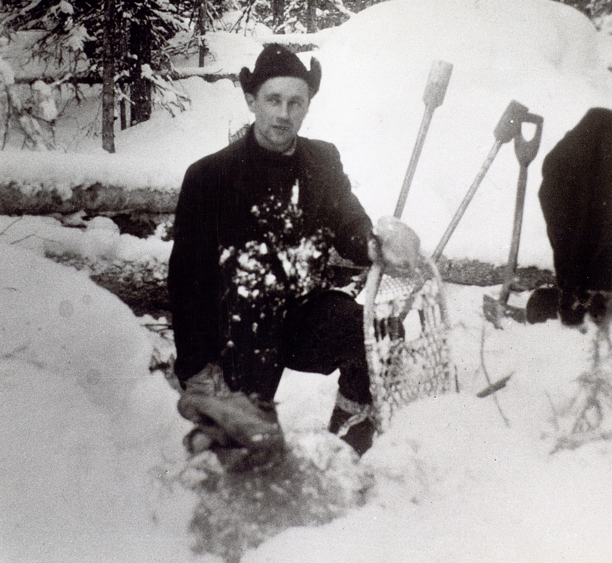 Lasse Westner på stolpsättning till Vakåsen 1954. Det var mycket snö och snöskorna kom väl till pass. I bakgrunden ett par klackspett.